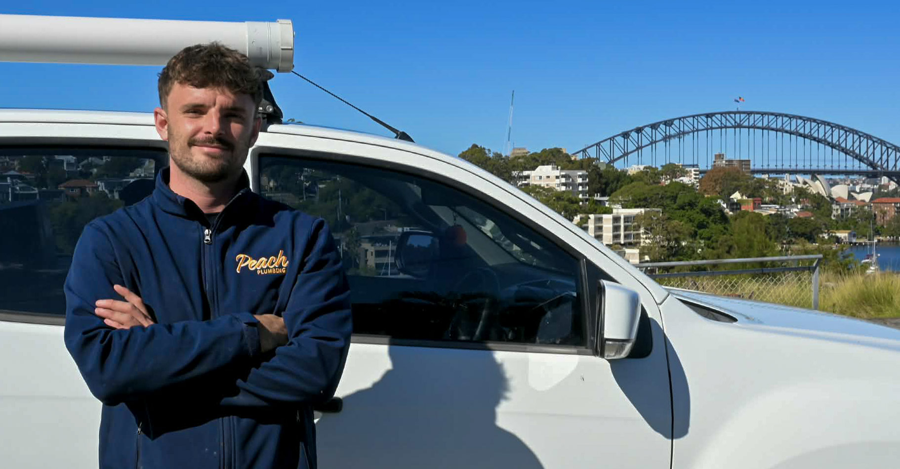 Tom from Peach Plumbing standing beside the Peach Plumbing van